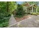 Landscaped exterior of the home, showcasing a wooded path to the porch at 4649 Dahlia Dr, Pine Lake, GA 30072