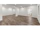 Open basement with laminate floors, support pillars, and light fixtures at 7059 Hunters Rdg, Woodstock, GA 30189