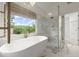 Luxurious bathroom featuring a modern tub, glass shower, and marble floors at 7059 Hunters Rdg, Woodstock, GA 30189