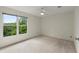 Bright bedroom with large window showcasing green outdoor views and light neutral carpeting at 7059 Hunters Rdg, Woodstock, GA 30189