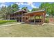 A multi-story clubhouse with covered patios and a pergola sitting on a lawn with mature landscaping at 7059 Hunters Rdg, Woodstock, GA 30189