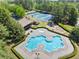 Aerial view of a community pool area with playground, seating, picnic pavilion, and tennis courts nearby at 7059 Hunters Rdg, Woodstock, GA 30189