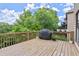 Spacious outdoor deck with wood flooring, grill, planters, and views of lush greenery at 7059 Hunters Rdg, Woodstock, GA 30189