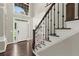 Welcoming foyer featuring wood floors, an elegant staircase, and a view of the front door and windows at 7059 Hunters Rdg, Woodstock, GA 30189