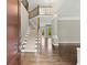 Elegant foyer featuring a staircase with carpeted steps, hardwood floors, and a view to the living area at 7059 Hunters Rdg, Woodstock, GA 30189