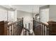Second story foyer with a wooden railing and a view of the staircase below at 7059 Hunters Rdg, Woodstock, GA 30189