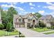 Traditional two-story home with three-car garage, stone facade, and manicured lawn at 7059 Hunters Rdg, Woodstock, GA 30189