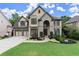 Charming two-story home with stone accents, three-car garage, manicured lawn and beautiful landscaping at 7059 Hunters Rdg, Woodstock, GA 30189
