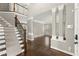Open-concept living room with decorative columns, hardwood floors, and a staircase leading to the second floor at 7059 Hunters Rdg, Woodstock, GA 30189