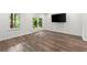 Bright living room with laminate flooring, French doors to the yard, and a mounted TV at 7059 Hunters Rdg, Woodstock, GA 30189