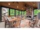 Screened-in porch with stone fireplace, wood ceiling, and casual dining furniture for outdoor entertaining at 7059 Hunters Rdg, Woodstock, GA 30189