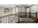 View of the staircase landing with wood floors, iron spindles, and a large arched window at 7059 Hunters Rdg, Woodstock, GA 30189