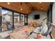 Inviting screened-in sunroom with wood ceiling, wicker furniture, ceiling fan, and large screen television at 7059 Hunters Rdg, Woodstock, GA 30189