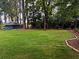 Spacious backyard featuring a lush green lawn, mature trees, and a charming storage shed at 894 Nottingham Dr, Avondale Estates, GA 30002