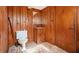 Rustic bathroom featuring knotty pine walls, a vintage toilet, and unique tile flooring at 894 Nottingham Dr, Avondale Estates, GA 30002