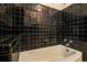 Modern bathroom featuring black tiled walls and a white bathtub at 894 Nottingham Dr, Avondale Estates, GA 30002