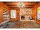 Inviting living room featuring a brick fireplace, built-in shelving, and wood-paneled walls at 894 Nottingham Dr, Avondale Estates, GA 30002