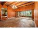 Spacious living room with wood-paneled walls, beamed ceilings, and sliding glass doors to a sunroom at 894 Nottingham Dr, Avondale Estates, GA 30002