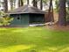 Charming green storage shed in a well-maintained backyard with lush lawn and mature trees at 894 Nottingham Dr, Avondale Estates, GA 30002
