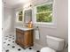 Cozy bathroom with a marble countertop vanity, wood cabinets, a framed mirror, and black and white tile floors at 1041 Standard Ne Dr, Brookhaven, GA 30319