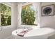 Bright bathroom featuring a classic soaking tub, decorative windows, and natural light at 1041 Standard Ne Dr, Brookhaven, GA 30319