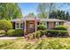 Inviting brick home with manicured landscaping, a front porch, and an American flag on display at 1041 Standard Ne Dr, Brookhaven, GA 30319