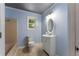 Well-lit bathroom with blue walls, a modern vanity, an oval mirror, and a shower-tub combination at 128 Reynolds Bridge Rd, Kingston, GA 30145