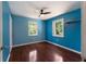 Bright bedroom with hardwood floors, blue walls, two windows overlooking the yard, and a ceiling fan at 128 Reynolds Bridge Rd, Kingston, GA 30145