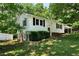 Charming exterior view with stone accents, black shutters, covered porch, and vibrant green landscaping at 128 Reynolds Bridge Rd, Kingston, GA 30145