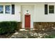 Close-up of the home's red front door, flanked by stone accents and black shutters at 128 Reynolds Bridge Rd, Kingston, GA 30145
