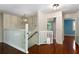 Bright hallway features hardwood floors, staircase, and view into other rooms at 128 Reynolds Bridge Rd, Kingston, GA 30145
