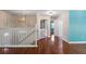 Bright hallway features hardwood floors, white railings, and a decorative chandelier leading to the bedrooms at 128 Reynolds Bridge Rd, Kingston, GA 30145