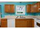 Bright kitchen with white appliances, oak cabinets, blue walls, and a window above the sink at 128 Reynolds Bridge Rd, Kingston, GA 30145