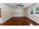 Open living room has hardwood floors, ceiling fan, and large windows providing natural light with a view of the yard at 128 Reynolds Bridge Rd, Kingston, GA 30145