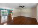 Open-concept living room with hardwood floors and a ceiling fan adjoining a kitchen and a sliding door to a deck at 128 Reynolds Bridge Rd, Kingston, GA 30145