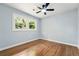 Bright bedroom boasts hardwood floors, a ceiling fan, and large windows framing the trees at 163 Oakcliff Ct, South Fulton, GA 30331