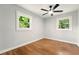 Bright bedroom features hardwood floors, ceiling fan and large windows offering wooded views at 163 Oakcliff Ct, South Fulton, GA 30331