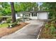 Charming one-story home with a long driveway, white exterior, black shutters, and freshly landscaped yard at 163 Oakcliff Ct, South Fulton, GA 30331