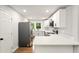 Well-lit kitchen with white cabinets, modern appliances, and view to the backyard at 163 Oakcliff Ct, South Fulton, GA 30331