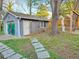 Backyard view of garage with mural, featuring a stone path and mature trees at 23 Gould Se St, Atlanta, GA 30315