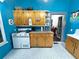 Retro kitchen with white appliances, wooden cabinets, and blue walls at 23 Gould Se St, Atlanta, GA 30315