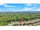 Drone eye view of townhomes surrounded by a forest with a lake in the distance at 635 Oakside Pl, Acworth, GA 30102