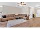 Spacious living room boasts hardwood floors, a ceiling fan, and a large brown sectional sofa at 635 Oakside Pl, Acworth, GA 30102