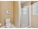 Bathroom with standard toilet, and tiled shower with glass doors and a window at 1300 Sever Woods Dr, Lawrenceville, GA 30043