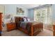 Cozy bedroom features a wooden bed frame, carpeted floor, and light blue walls with an abstract art piece at 1300 Sever Woods Dr, Lawrenceville, GA 30043