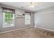 Carpeted bedroom features neutral paint, shelving and two large windows for natural light at 1300 Sever Woods Dr, Lawrenceville, GA 30043