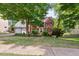 Beautiful brick home with mature trees, manicured lawn, and a two-car garage on a sunny day at 1300 Sever Woods Dr, Lawrenceville, GA 30043