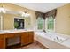 Bright main bathroom with soaking tub under window, large vanity area and lots of counter space at 1300 Sever Woods Dr, Lawrenceville, GA 30043