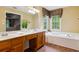Bright main bathroom with soaking tub under window and large vanity area with lots of counter space at 1300 Sever Woods Dr, Lawrenceville, GA 30043