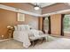 Spacious main bedroom featuring a tray ceiling, neutral paint, bench and lots of natural light at 1300 Sever Woods Dr, Lawrenceville, GA 30043